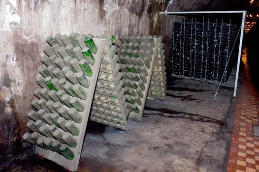 Stack of wine bottles in winery. Shampagne wine storage