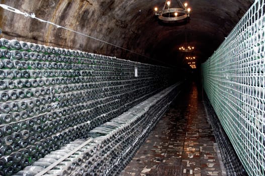 Stack of wine bottles in winery. Shampagne wine storage