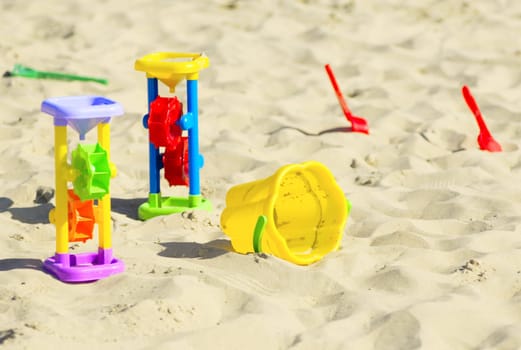 Children`s toys for sand and sunblock lotion at the beach. Summer vacations concept