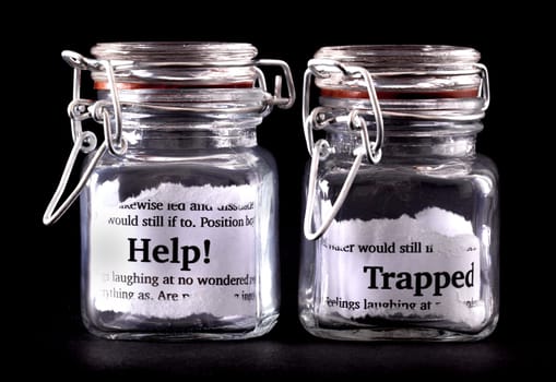 Two closed jars with messages of help and trapped on paper inside