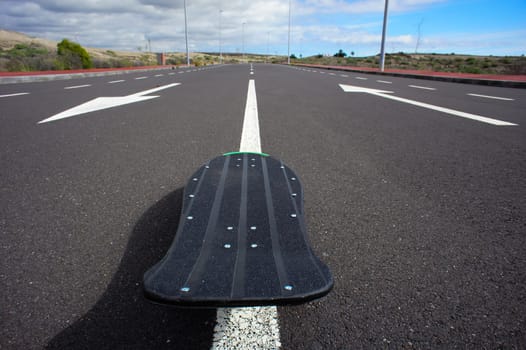 Vintage Style Longboard Black Skateboard on an Empty Asphalt Desert Road