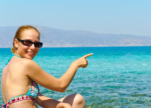 Beautiful young woman in swimsuit, relaxing on a tropical sunny beach