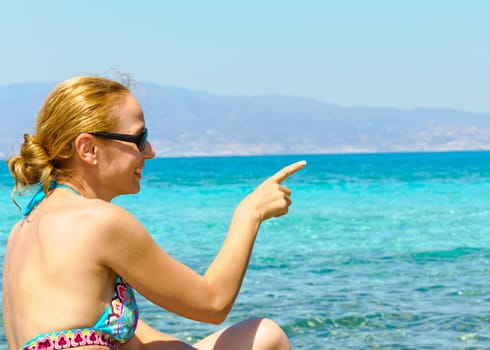 Beautiful young woman in swimsuit, relaxing on a tropical sunny beach