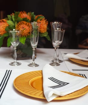 View of elegant table set with orange flowers