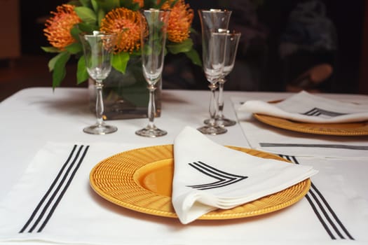 View of elegant table set with orange flowers