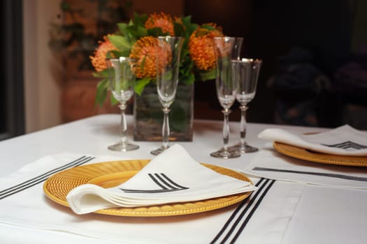 View of elegant table set with orange flowers