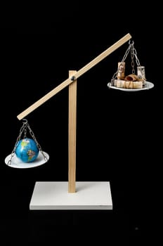 Globe Planet Earth and Money on a Two Pan Balance