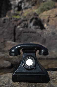 International Communications Vintage Telephone Toy on the Volcanic Rocks