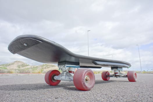 Vintage Style Longboard Black Skateboard on an Empty Asphalt Desert Road