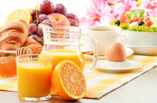 Breakfast with coffee, orange juice, croissant, egg, vegetables and fruits