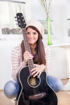 cute young girl holding the guitar and smiling