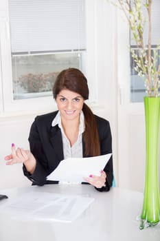 smiling business woman with papers on table