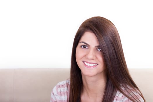 sweet girl smiling while sitting on the couch at home