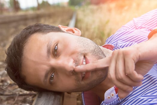 male model possing and lying on the rail
