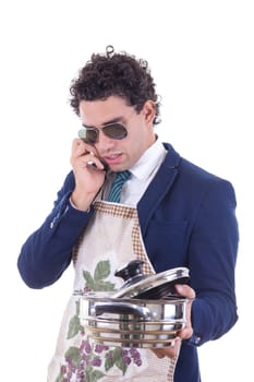 man in suit with an apron holding a cooking pot and talking over phone