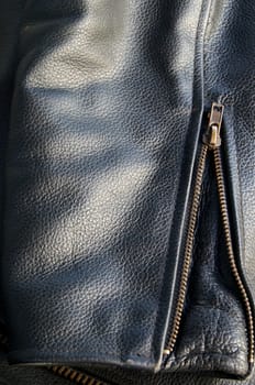 close up of sleeve of buffalo hide motorcycle jacket showing detail of skin and brass zipper.