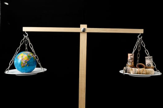 Globe Planet Earth and Money on a Two Pan Balance
