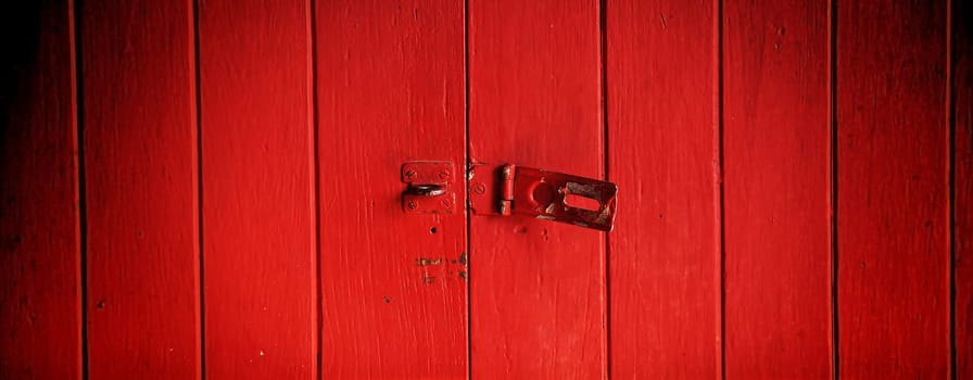 Old padlock on a red wooden door