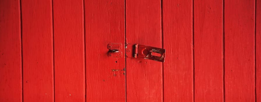 Old padlock on a red wooden door