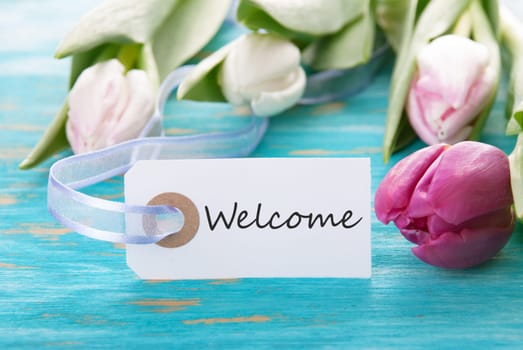 Tag with Welcome on turquoise Board with Tulip Flower