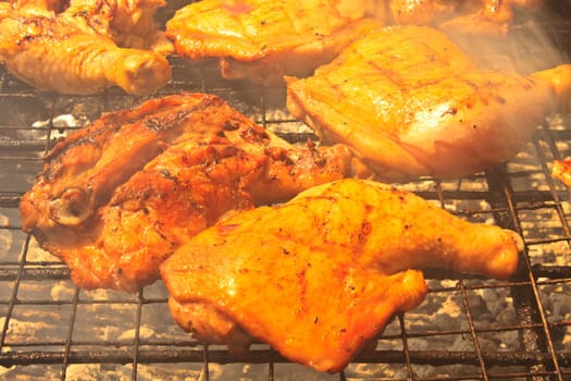 Grilled chicken thigh on the flaming grill