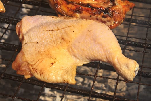 Grilled chicken thigh on the flaming grill