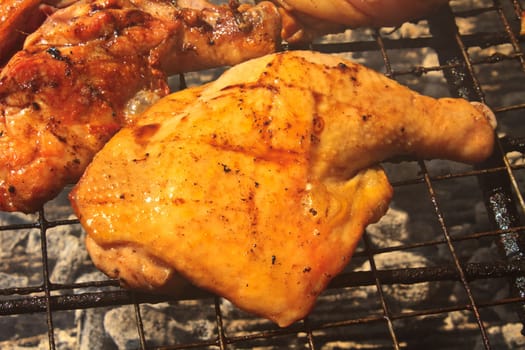 Grilled chicken thigh on the flaming grill
