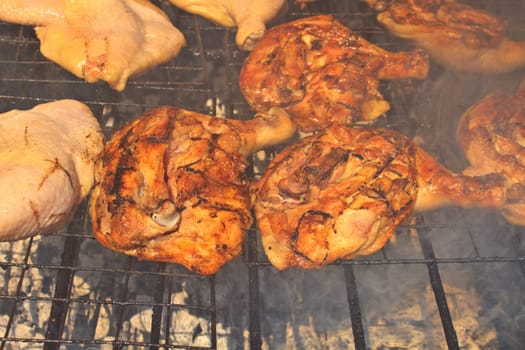 Grilled chicken thigh on the flaming grill