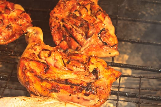 Grilled chicken thigh on the flaming grill