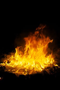 Flames and smoke fill this image of a ceremonial fire during a mayan ritual.