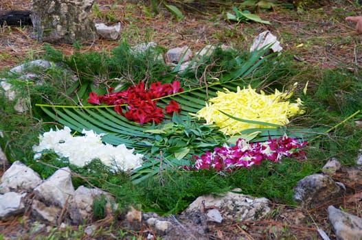 A fire pit surrounded by rocks is being prepared for a mayan ceremony, showing various offerings to the gods.