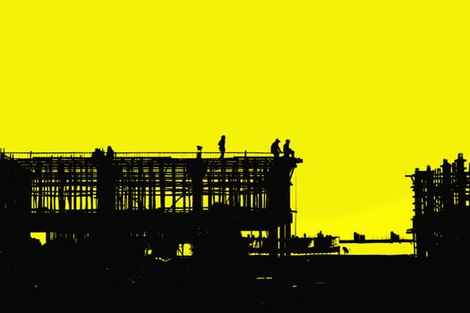Construction worker working on a construction site on silhouettes