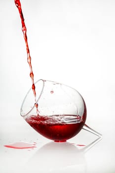 A broken glass filled with red liquid
