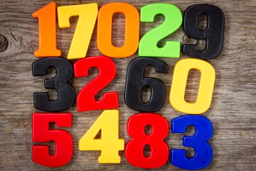 Colorful plastic numbers on the wooden background