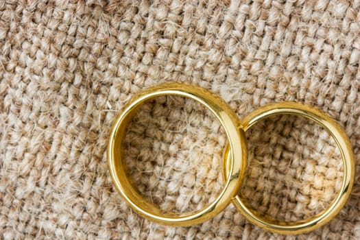 Two golden wedding rings on the burlap