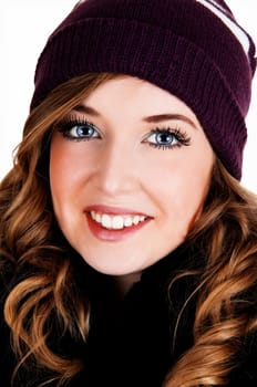 A closeup picture of a pretty young woman with nice blue eyes and curly.long hair with a knitted burgundy hat..