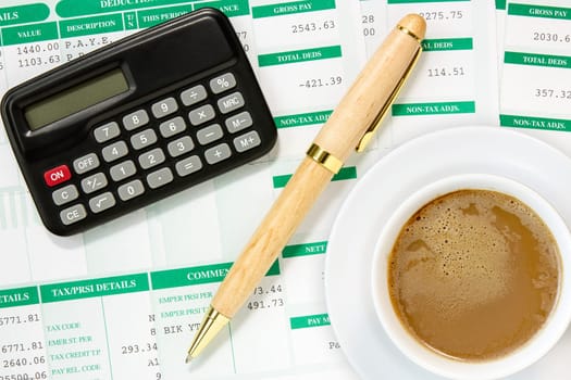 Calculator and coffee cup  in an environment of financial calculations