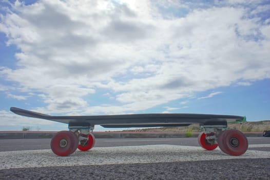 Vintage Style Longboard Black Skateboard on an Empty Asphalt Desert Road