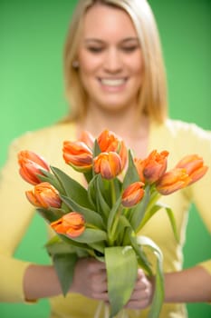 Bouquet of orange spring tulip flowers smiling woman in background