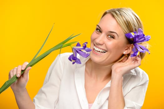 Smiling woman with spring iris flower in her hair