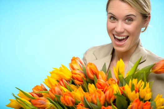 Cheerful woman with bunch of orange yellow spring tulips
