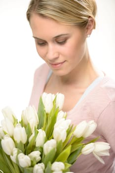 Lovely woman looking down white spring flowers bouquet of tulips