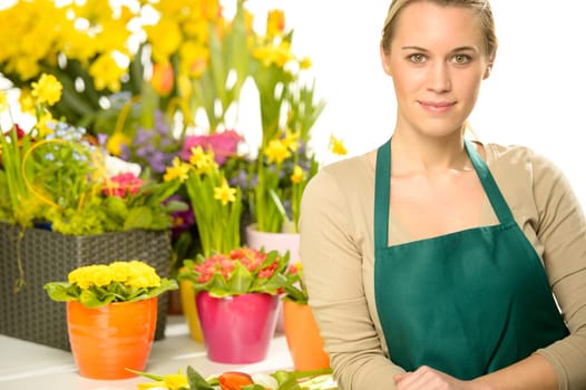 Florist with spring potted flowers colorful looking at camera