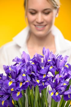 Bouquet of blue spring iris flowers smiling woman in background