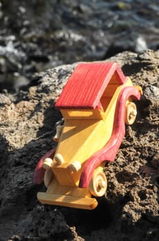 Transportation Concept Wooden Toy Car on the Rocks