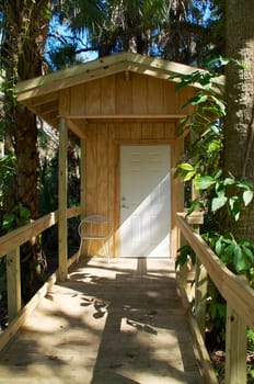 View of newly constructed modern outhouse with handicapped ramp in nature.