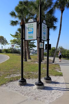 SARASOTA, FLORIDA - MAY 9, 2013: A woman getting healthy and fit with some early morning exercise by jogging the Bayfront Multi-use Recreational Trail sidewalk on a sunny, tropical day.