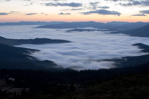 Sunrise in the mountains above the clouds