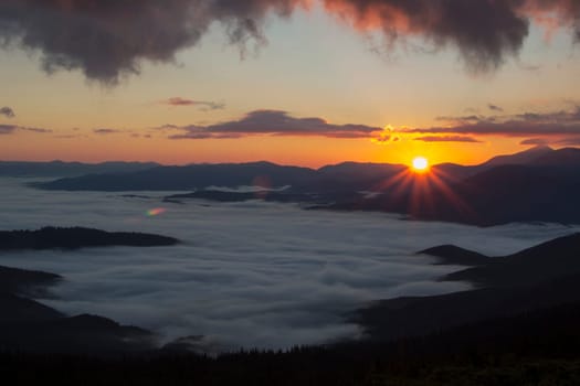 Sunrise in the mountains above the clouds
