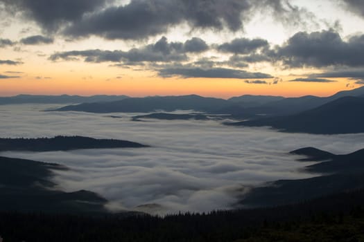 Sunrise in the mountains above the clouds